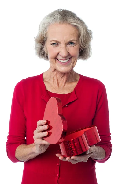 Senior woman with heart shaped gift box — Stock Photo, Image