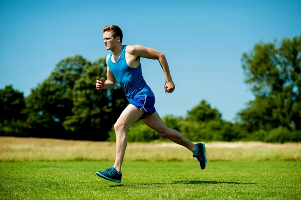 God idrettsutøver som løper hardt på en solrik dag – stockfoto