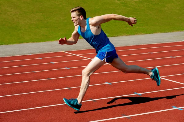 Young caucasian athlete sprinting on track — Stock Photo, Image