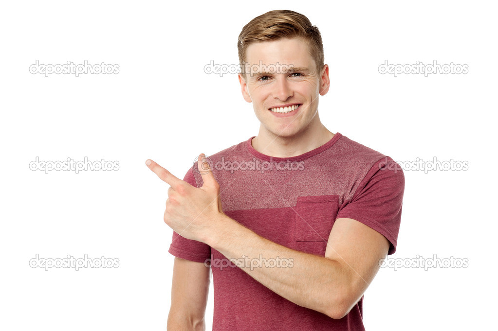 Young cheerful man pointing away