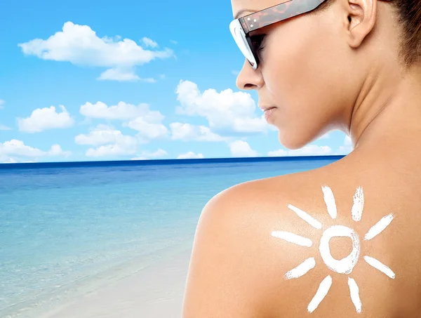Junge Frau mit Sonnencreme auf dem Rücken — Stockfoto