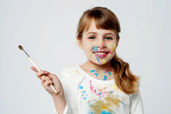 Cute little girl with a painting brush — Stock Photo, Image