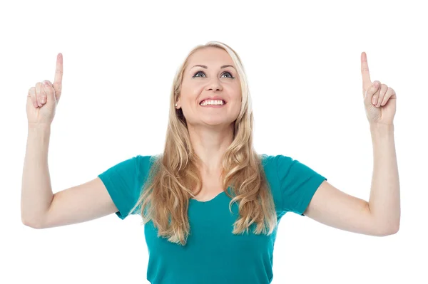Casual woman looking and pointing upwards — Stock Photo, Image