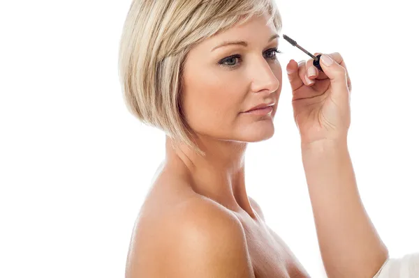 Beautiful female model getting makeup done — Stock Photo, Image