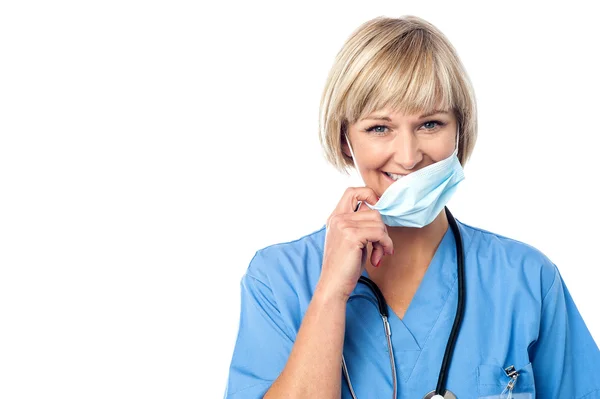 Senior female surgeon removing medical mask — Stock Photo, Image