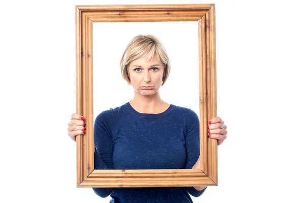 Mujer triste sosteniendo marco de imagen —  Fotos de Stock