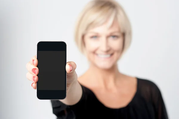 Woman displaying new phone in market — Stock Photo, Image