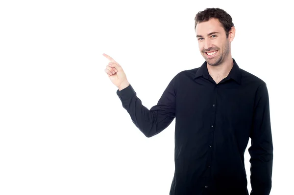 Handsome young guy pointing at something — Stock Photo, Image