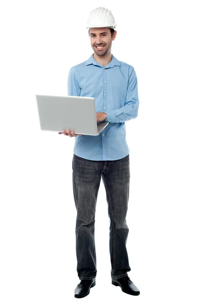 Cheeful builder navegando em seu laptop — Fotografia de Stock