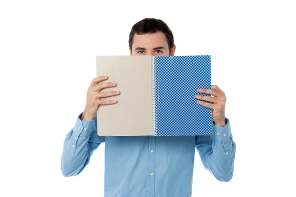 Mladý muž schovává tvář s notebookem — Stock fotografie