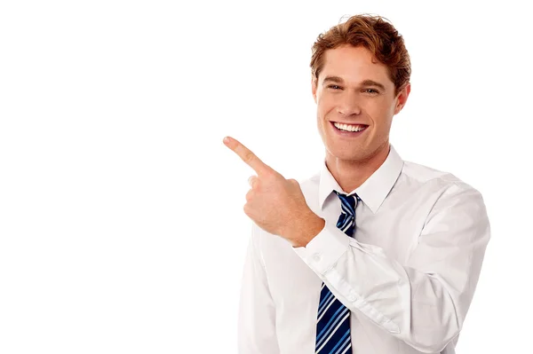 Smiling businessman pointing away — Stock Photo, Image