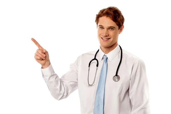Sorridente giovane medico che indica lontano — Foto Stock