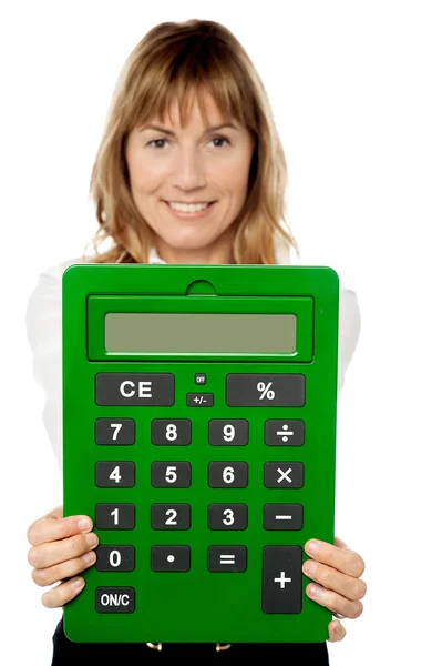 Senhora mostrando grande calculadora verde — Fotografia de Stock