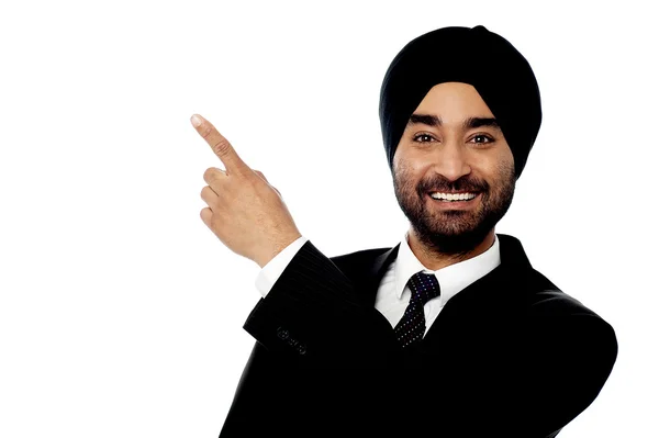 Smiling businessman pointing away — Stock Photo, Image