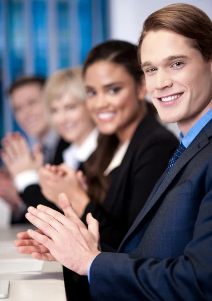 Corporate team zitten in een rij en applaudisseren — Stockfoto