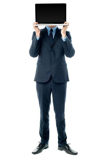 Businessman covering his face with laptop — Stock Photo, Image