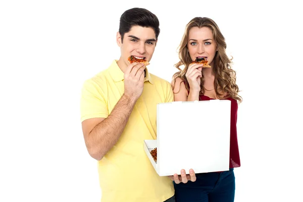 Couple enjoying pizza slices — Stock Photo, Image