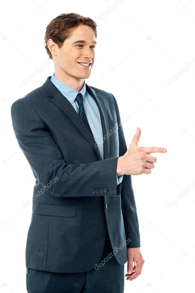Cheerful businessman pointing away