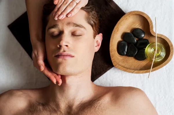 Relaxed young guy getting a face massage — Stock Photo, Image