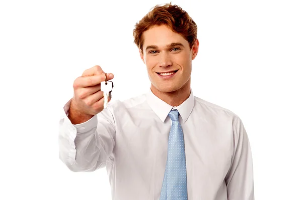 Sonriente hombre ofreciendo llave de la casa — Foto de Stock