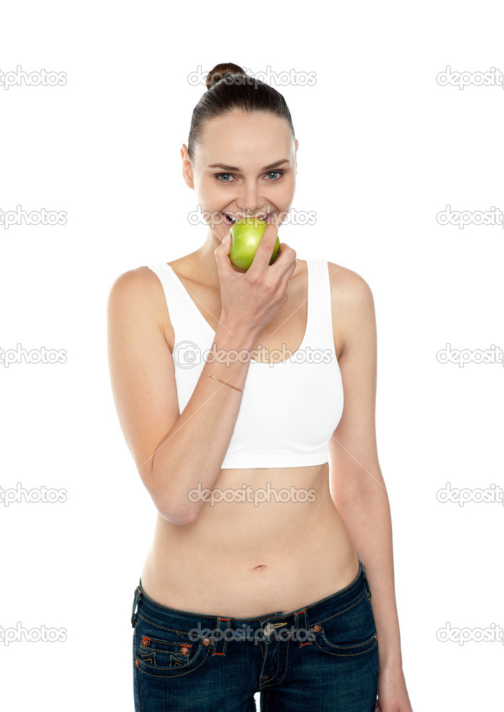 Fitness woman eating green apple