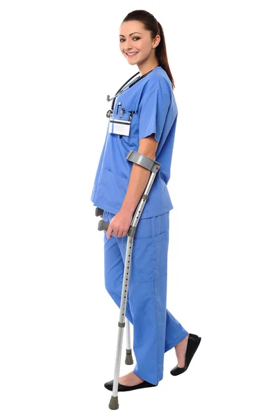 Lady doctor walking with help of crutches — Stock Photo, Image