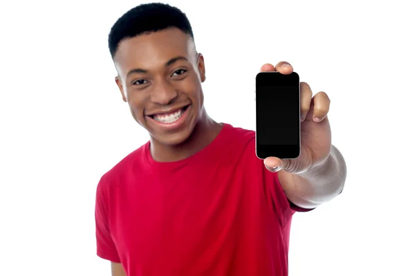 Chico joven mostrando nuevo teléfono celular — Foto de Stock