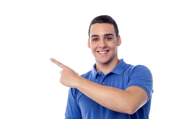 Cheerful teenager pointing away — Stock Photo, Image