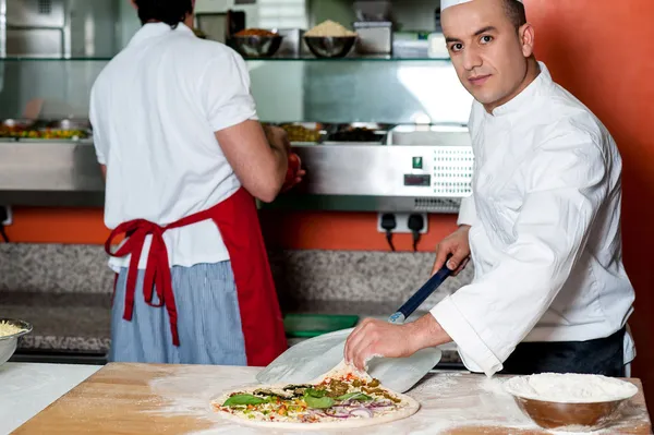 Druk bij de voorbereiding van pizza chef-kok — Stockfoto