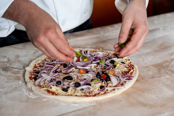 Шеф-повар готовит пиццу, крупный план — стоковое фото