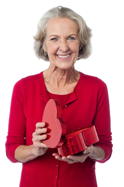 Senior woman with heart shaped gift box — Stock Photo, Image