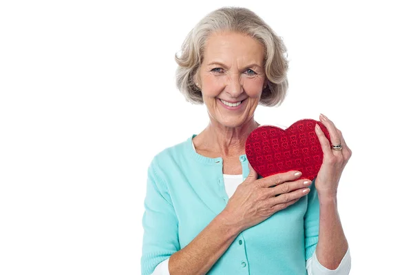 Mulher idosa segurando uma caixa de presente valentine vermelho — Fotografia de Stock