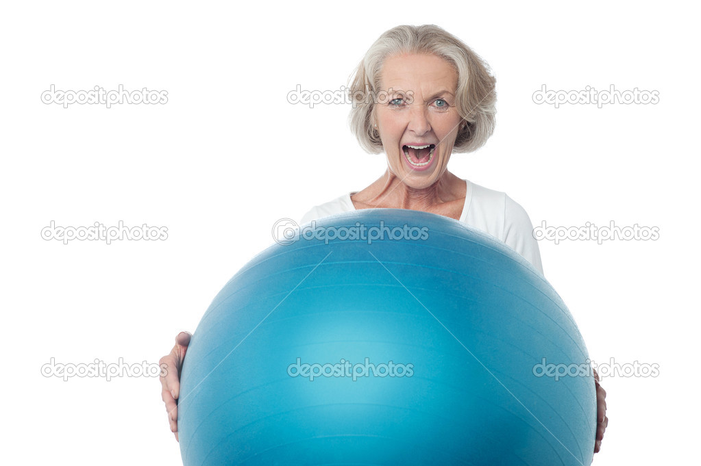 Aged woman posing with exercise ball