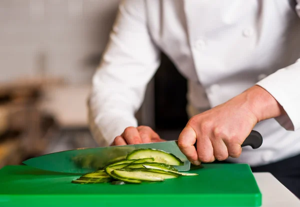 Chef cortando alho-porro, fazendo preparações — Fotografia de Stock