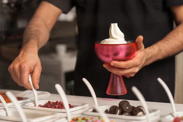 Uomo che guarnisce il gelato con gemme e gelatine — Foto Stock