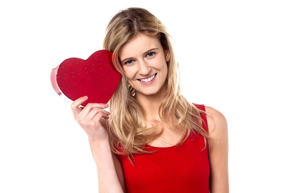 Smiling teen girl showing heart shape gift to camera — Stock Photo, Image