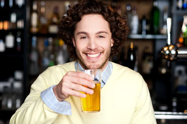 Giovane uomo positivo che tiene un bicchiere di birra — Foto Stock