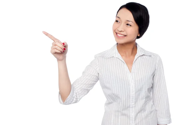 Happy young girl pointing at copy space area — Stock Photo, Image