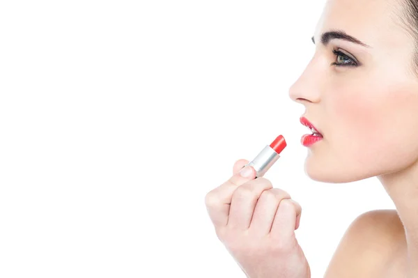 Atractiva chica adolescente aplicando lápiz labial rojo —  Fotos de Stock