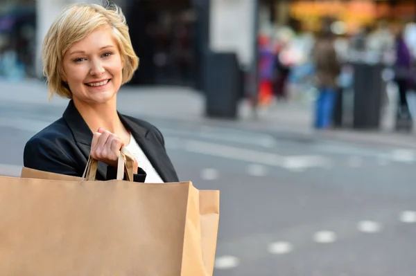 Vrolijke zakenvrouw houden boodschappentas — Stockfoto