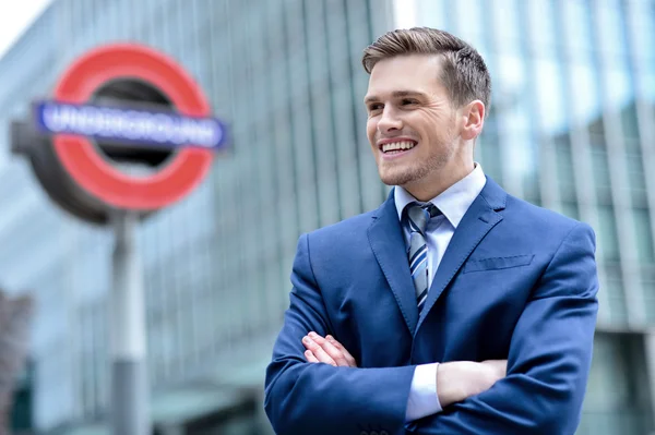 Young businessman standing in front of buildings — Stock Photo, Image