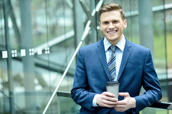 笑みを浮かべて、コーヒーのカップを持ったビジネスマン — ストック写真