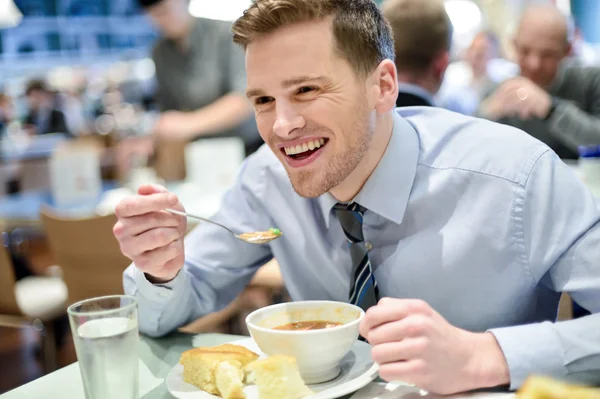 Jovem empresário sorrindo almoçando — Fotografia de Stock