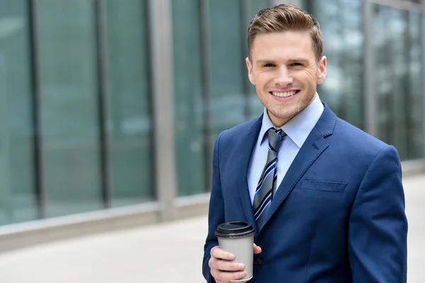 Empresário sorridente com sipper café — Fotografia de Stock