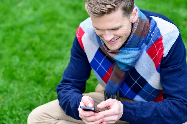 Gelukkig lachende man met behulp van mobiele telefoon op park — Stockfoto