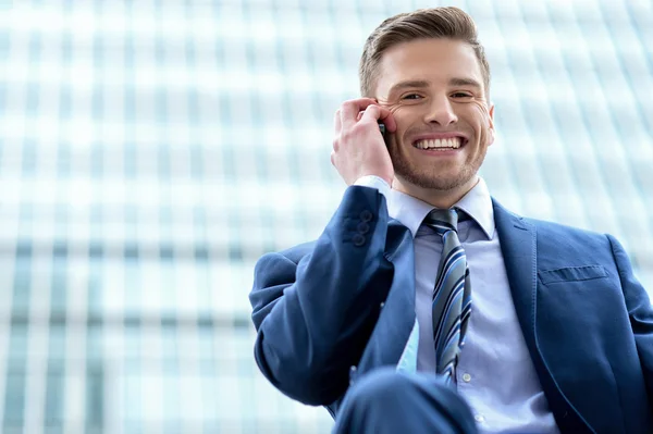 Businessman talking on phone outdoors — Stock Photo, Image