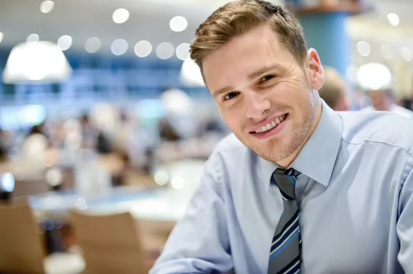 Lachende jonge man ontspannen in restaurant — Stockfoto