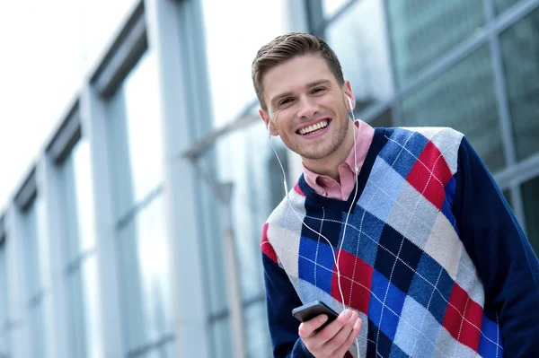 Schöner junger Mann hört Musik — Stockfoto