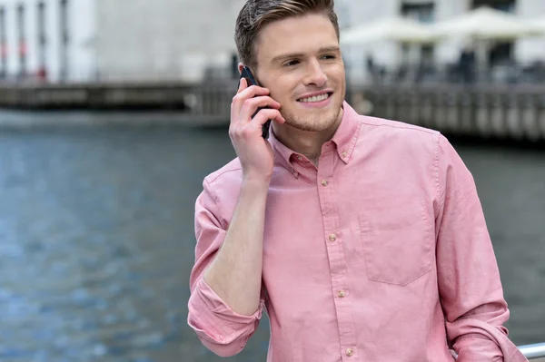 Młody mężczyzna rozmawia przez telefon komórkowy — Zdjęcie stockowe