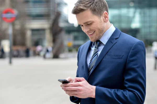 Młody biznesmen za pomocą swojego telefonu komórkowego — Zdjęcie stockowe